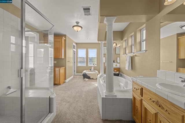 bathroom with decorative columns, vanity, and independent shower and bath