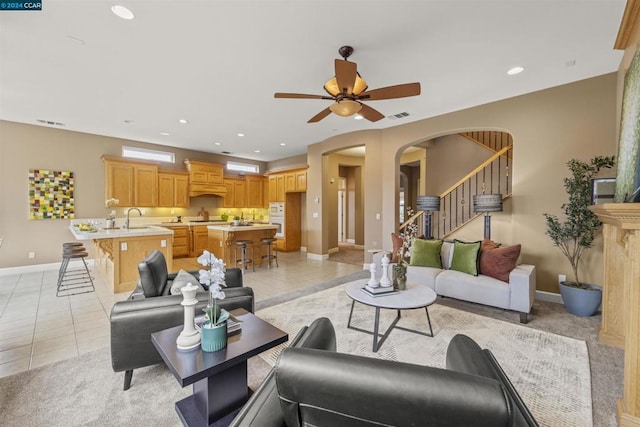 living room featuring ceiling fan, light tile patterned floors, and sink