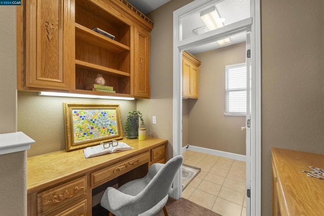 office space featuring light tile patterned floors and built in desk