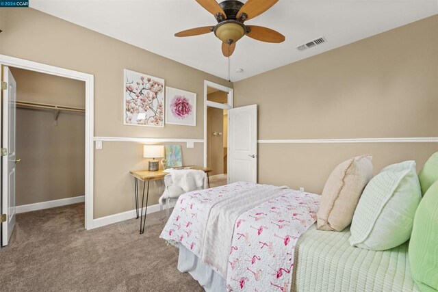 carpeted bedroom with a closet, a spacious closet, and ceiling fan