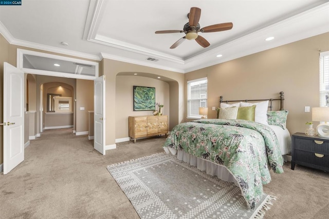 bedroom with ceiling fan, light colored carpet, ornamental molding, and multiple windows