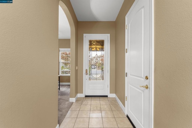 doorway to outside with light tile patterned floors