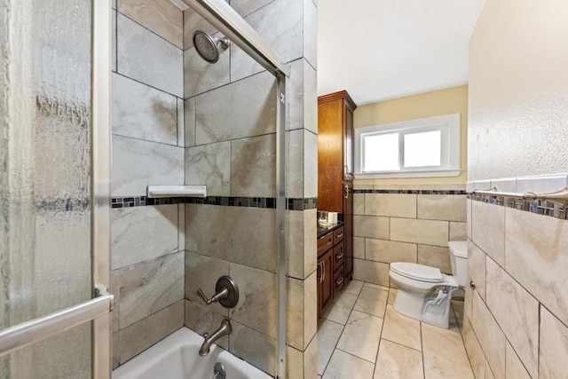 bathroom featuring toilet, tile walls, and tiled shower / bath combo