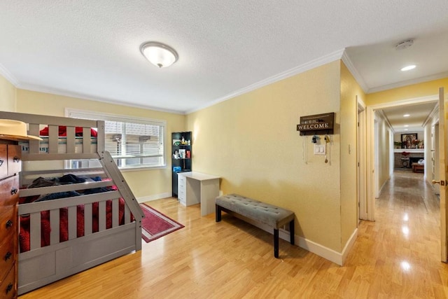 bedroom with a textured ceiling, crown molding, and wood-type flooring