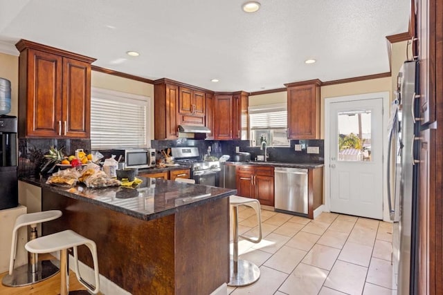 kitchen with kitchen peninsula, stainless steel appliances, sink, and a kitchen bar