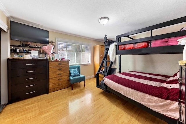 bedroom featuring ornamental molding and light hardwood / wood-style flooring