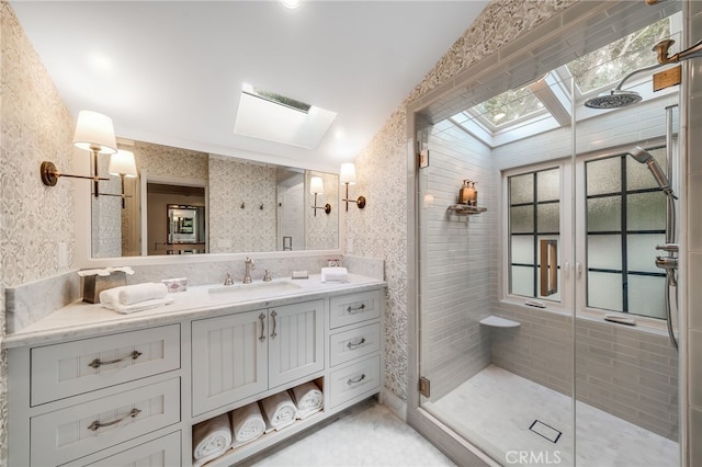 bathroom with a stall shower, a skylight, vanity, and wallpapered walls