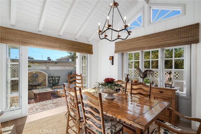 dining area with an inviting chandelier, plenty of natural light, and beamed ceiling