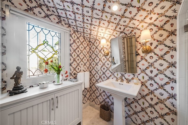 bathroom with baseboards and wallpapered walls