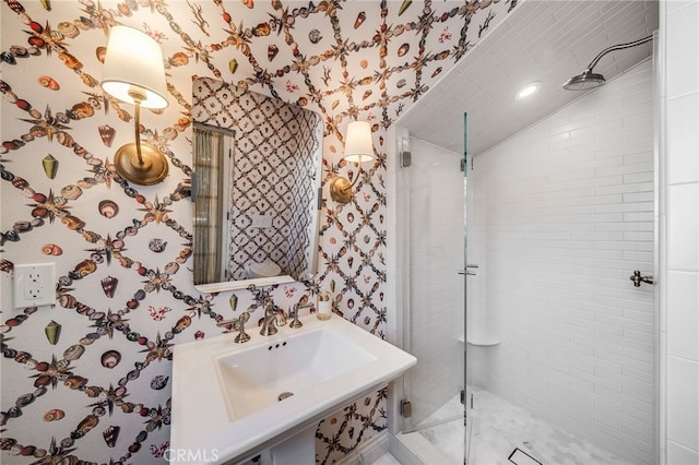 bathroom featuring wallpapered walls, vaulted ceiling, and tiled shower