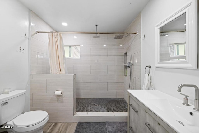 bathroom with a shower with shower curtain, vanity, hardwood / wood-style flooring, and toilet