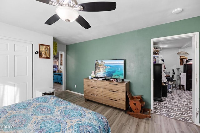 bedroom with a closet, ceiling fan, and light hardwood / wood-style flooring