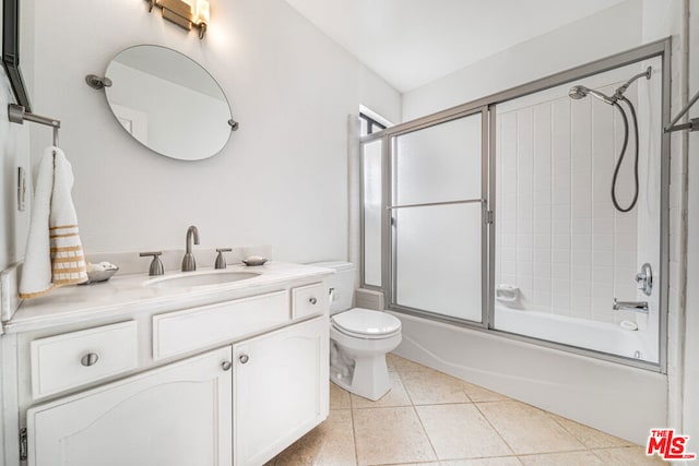 full bathroom featuring toilet, vanity, tile patterned floors, and enclosed tub / shower combo