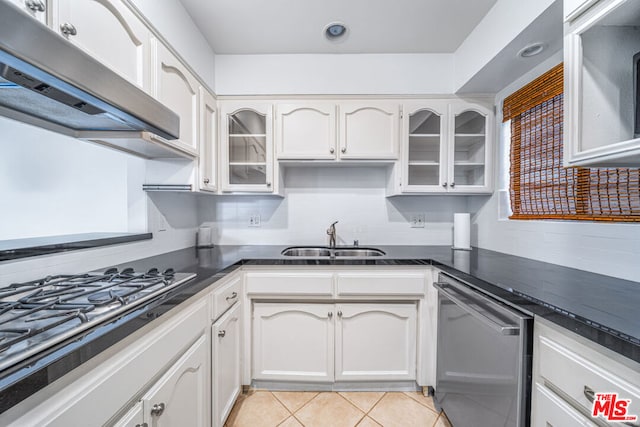 kitchen featuring white cabinets, sink, decorative backsplash, appliances with stainless steel finishes, and light tile patterned flooring