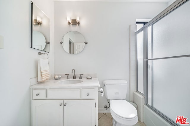 full bathroom featuring shower / bath combination with glass door, tile patterned floors, vanity, and toilet