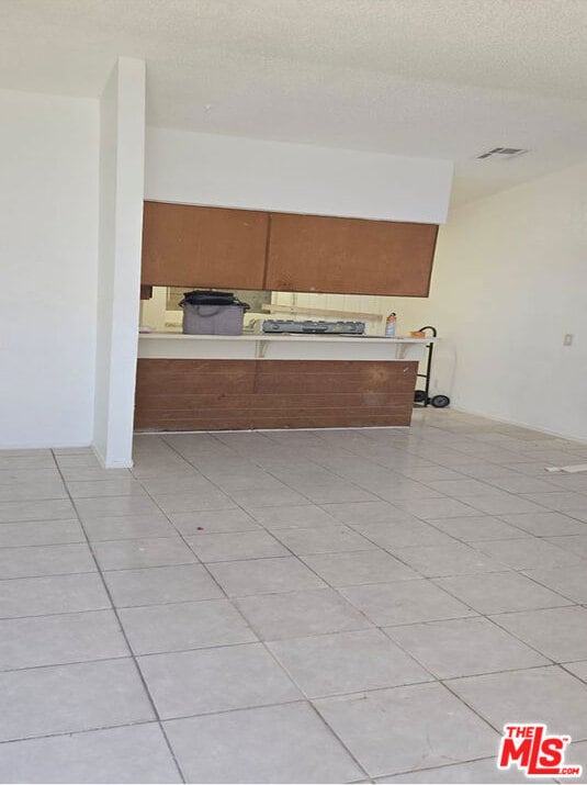 unfurnished room featuring light tile patterned floors and a textured ceiling