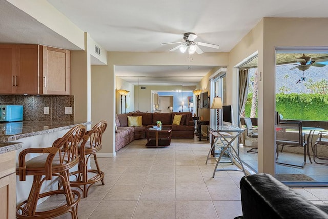 tiled living room featuring ceiling fan