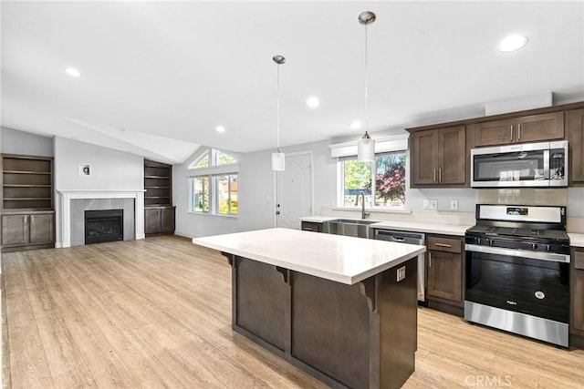 kitchen with a breakfast bar, appliances with stainless steel finishes, plenty of natural light, and hanging light fixtures