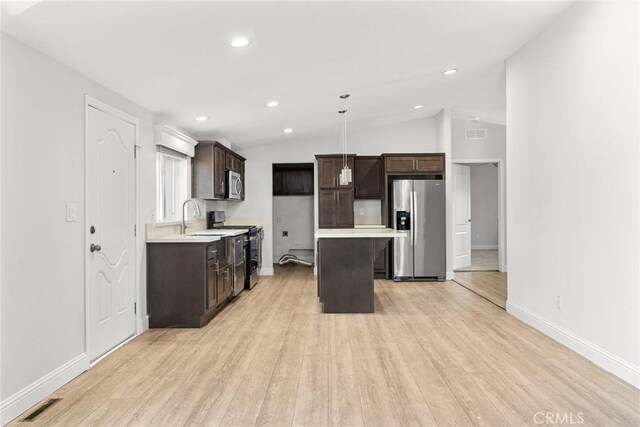 511 Montgomery, Paradise, CA 95969 - kitchen featuring appliances with stainless steel finishes, dark brown cabinetry, a center island, light wood-type flooring, and vaulted ceiling