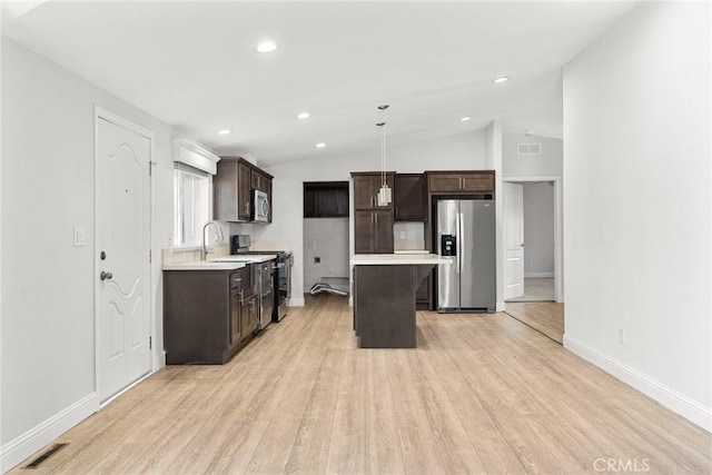 511 Montgomery, Paradise, CA 95969 - kitchen featuring appliances with stainless steel finishes, dark brown cabinetry, a center island, light wood-type flooring, and vaulted ceiling