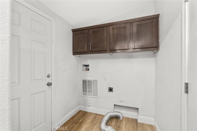 laundry room with cabinets, hookup for a washing machine, light hardwood / wood-style flooring, and electric dryer hookup