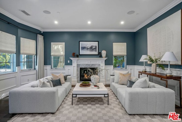 living room with crown molding and a high end fireplace