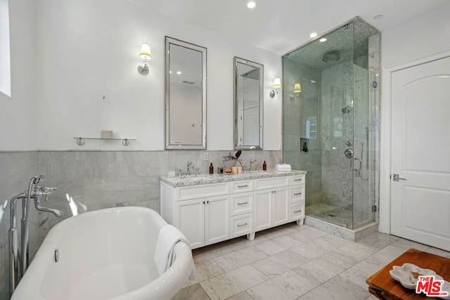 bathroom featuring vanity and independent shower and bath