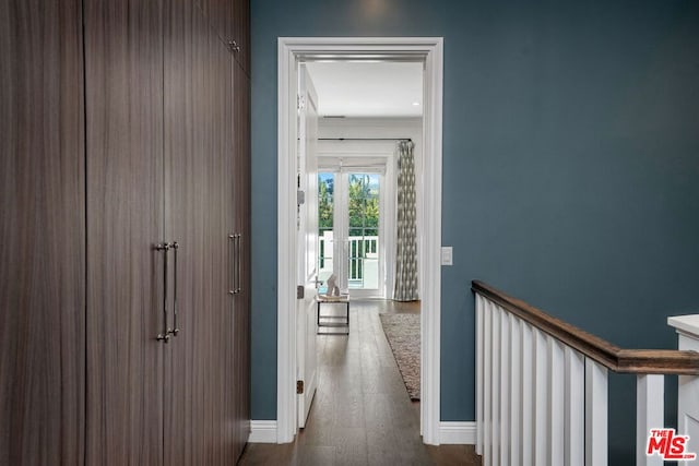 hallway with wood-type flooring and crown molding