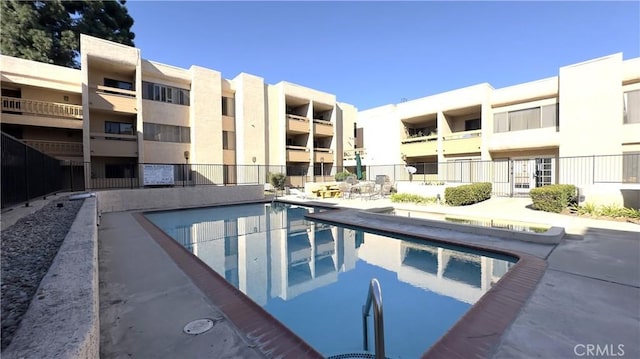 pool with fence and a patio