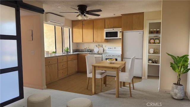 kitchen featuring a textured ceiling, white appliances, a sink, a ceiling fan, and an AC wall unit