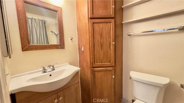 full bath featuring toilet, curtained shower, and vanity