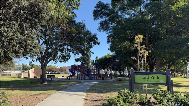 view of property's community featuring playground community and a yard