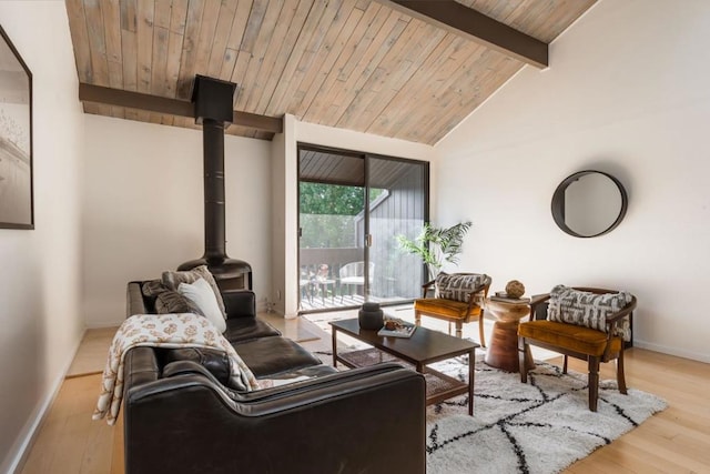 living room featuring wood ceiling, a wood stove, light hardwood / wood-style flooring, and vaulted ceiling with beams