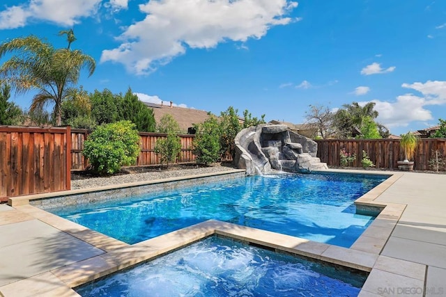 view of pool featuring an in ground hot tub and a water slide