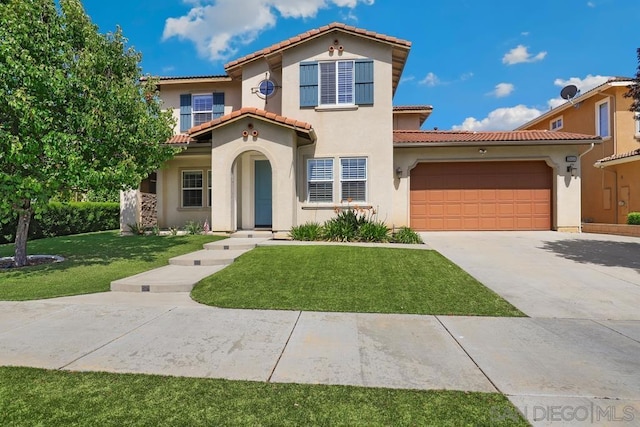 mediterranean / spanish home with a garage and a front lawn