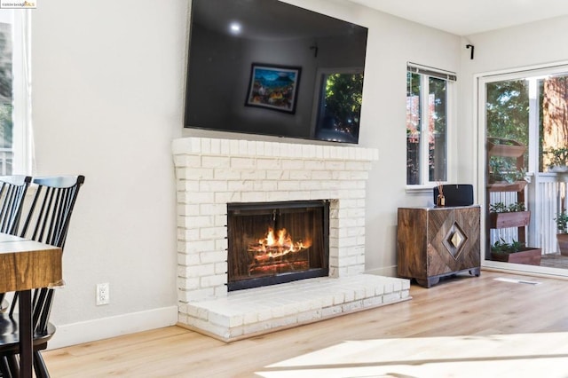 living area featuring hardwood / wood-style floors and a brick fireplace