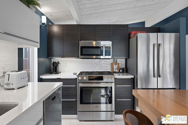 kitchen featuring vaulted ceiling with beams, light tile patterned flooring, appliances with stainless steel finishes, and tasteful backsplash