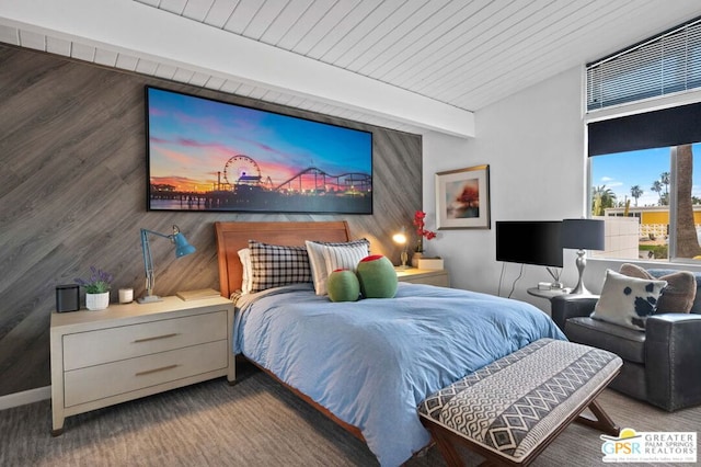 bedroom with beamed ceiling and wooden walls