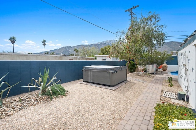 view of patio / terrace featuring a mountain view and a hot tub