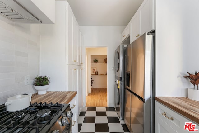 kitchen featuring white cabinets, appliances with stainless steel finishes, tasteful backsplash, and butcher block counters