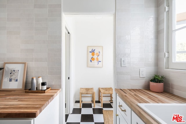 bathroom featuring sink and tile walls