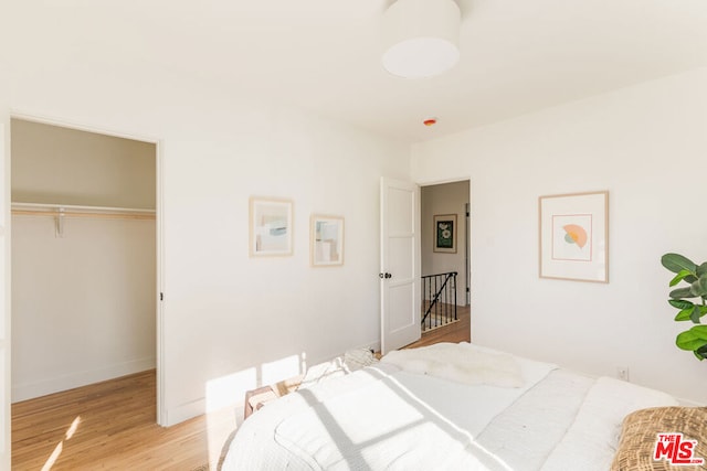 bedroom with light hardwood / wood-style flooring and a closet