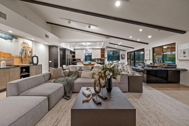 living room with light hardwood / wood-style flooring and lofted ceiling with beams