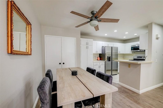 dining area with ceiling fan and light hardwood / wood-style flooring