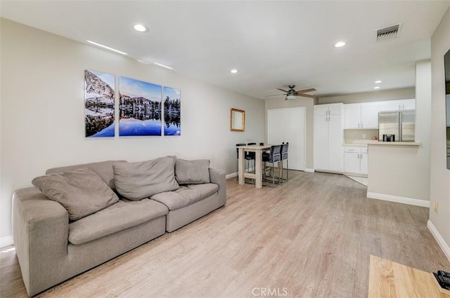 living room with ceiling fan and light hardwood / wood-style floors