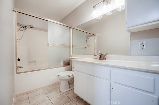 full bathroom featuring shower / bath combination with glass door, vanity, tile patterned floors, and toilet