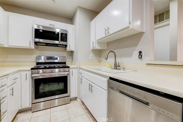 kitchen with white cabinets, light tile patterned floors, stainless steel appliances, and sink