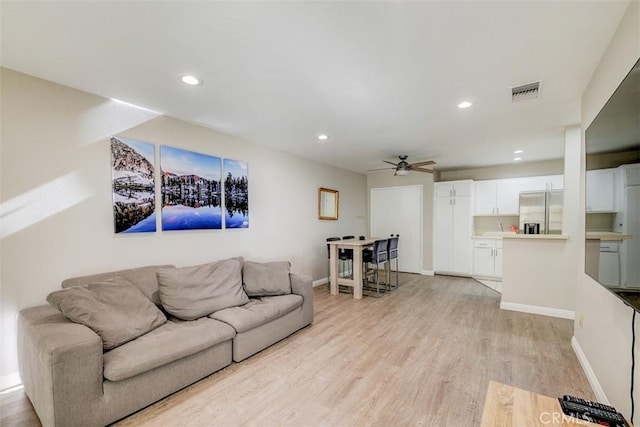 living room with ceiling fan and light hardwood / wood-style floors