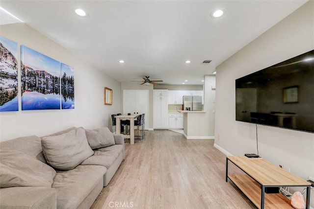 living room featuring ceiling fan and light hardwood / wood-style flooring