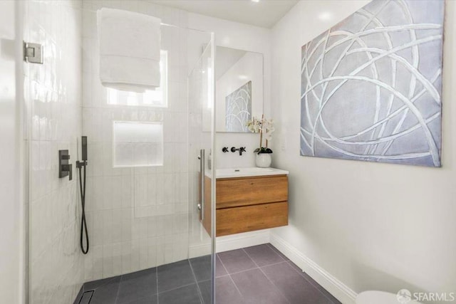 bathroom featuring a tile shower, tile patterned floors, and vanity